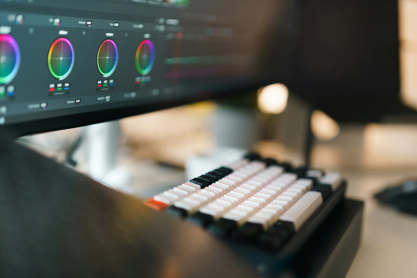 Color grading software on a computer monitor with a mechanical keyboard.